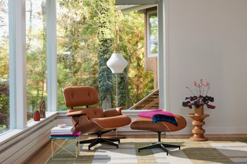 brown eames chair with a side table with a view