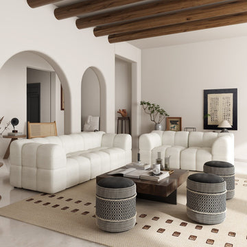 Boho-inspired living room featuring boucle sofas adorned with boho poufs and a wooden coffee table