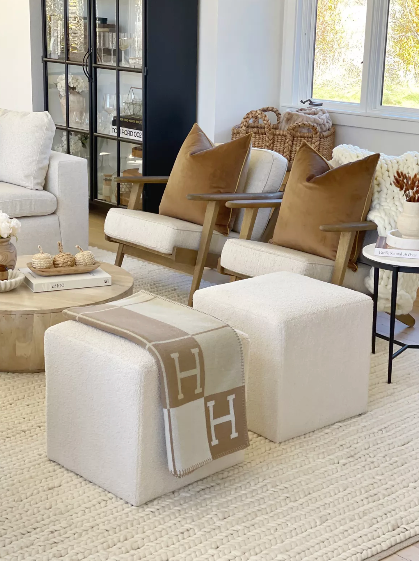 Hermès H Blanket elegantly draped over a white sofa, adding a touch of luxury to the living room decor.