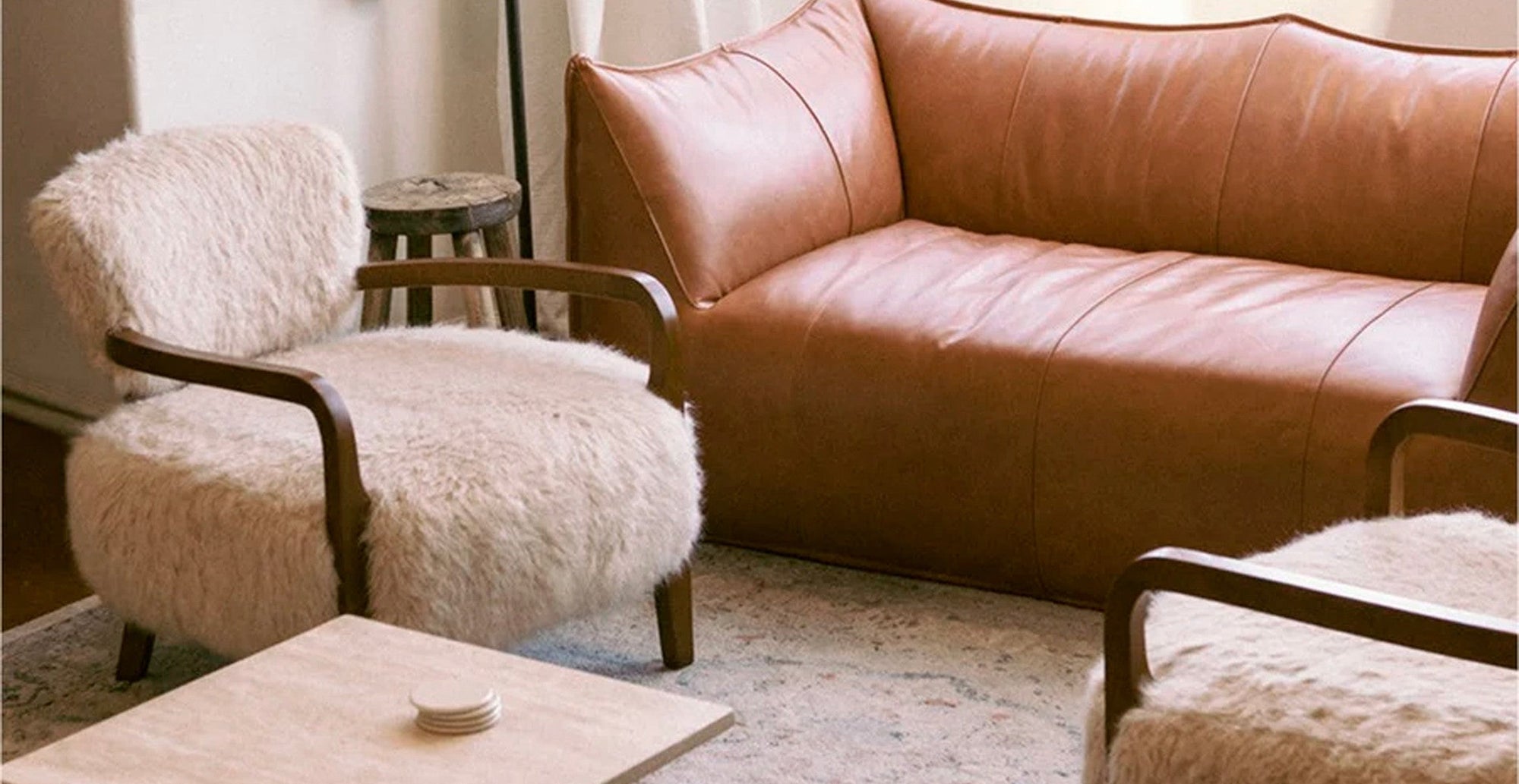 Cozy sheepskin armchair paired with a luxury leather sofa in a modern organic living room design