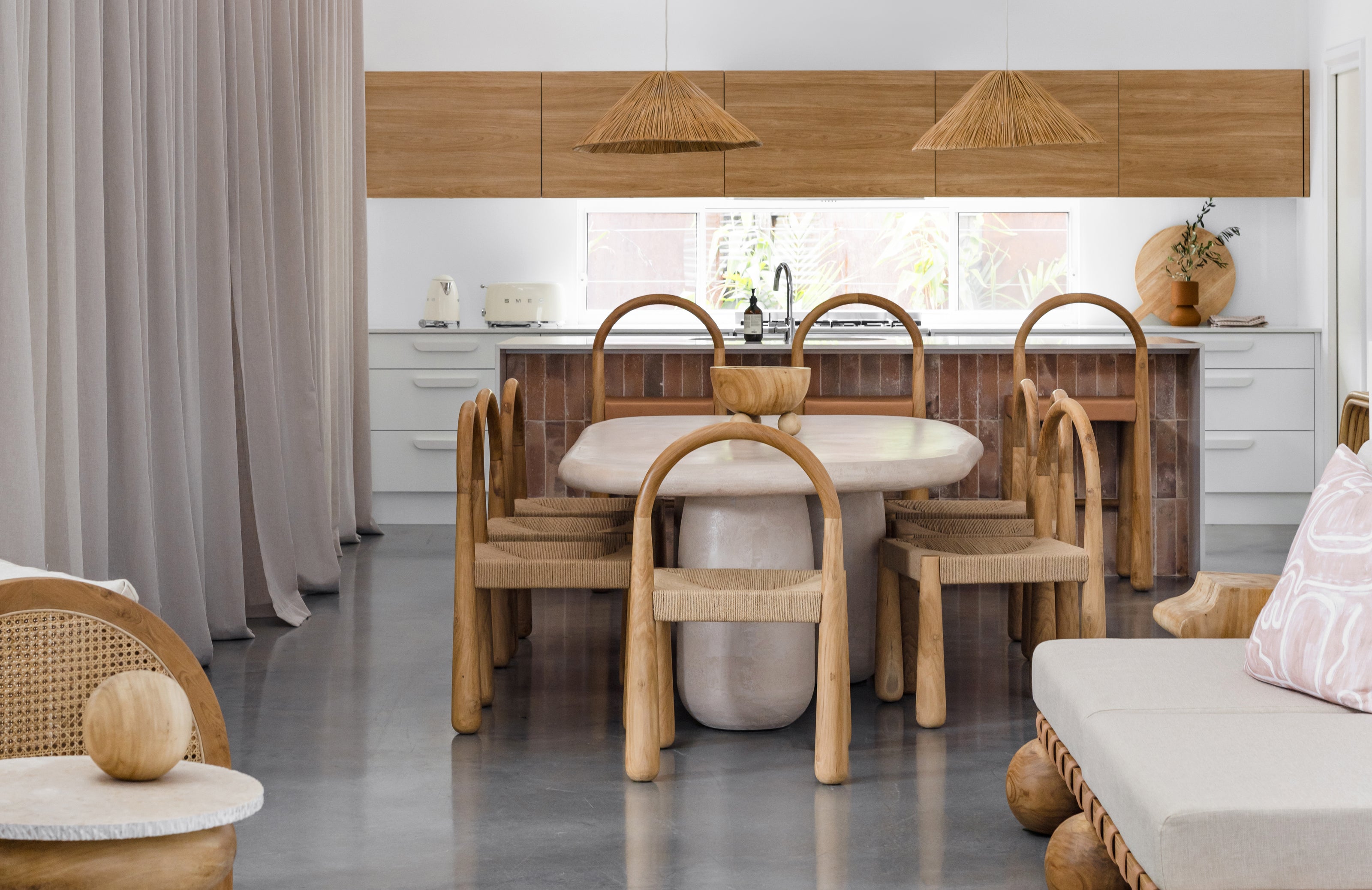 Dining area with wooden furniture and a kitchen in the background