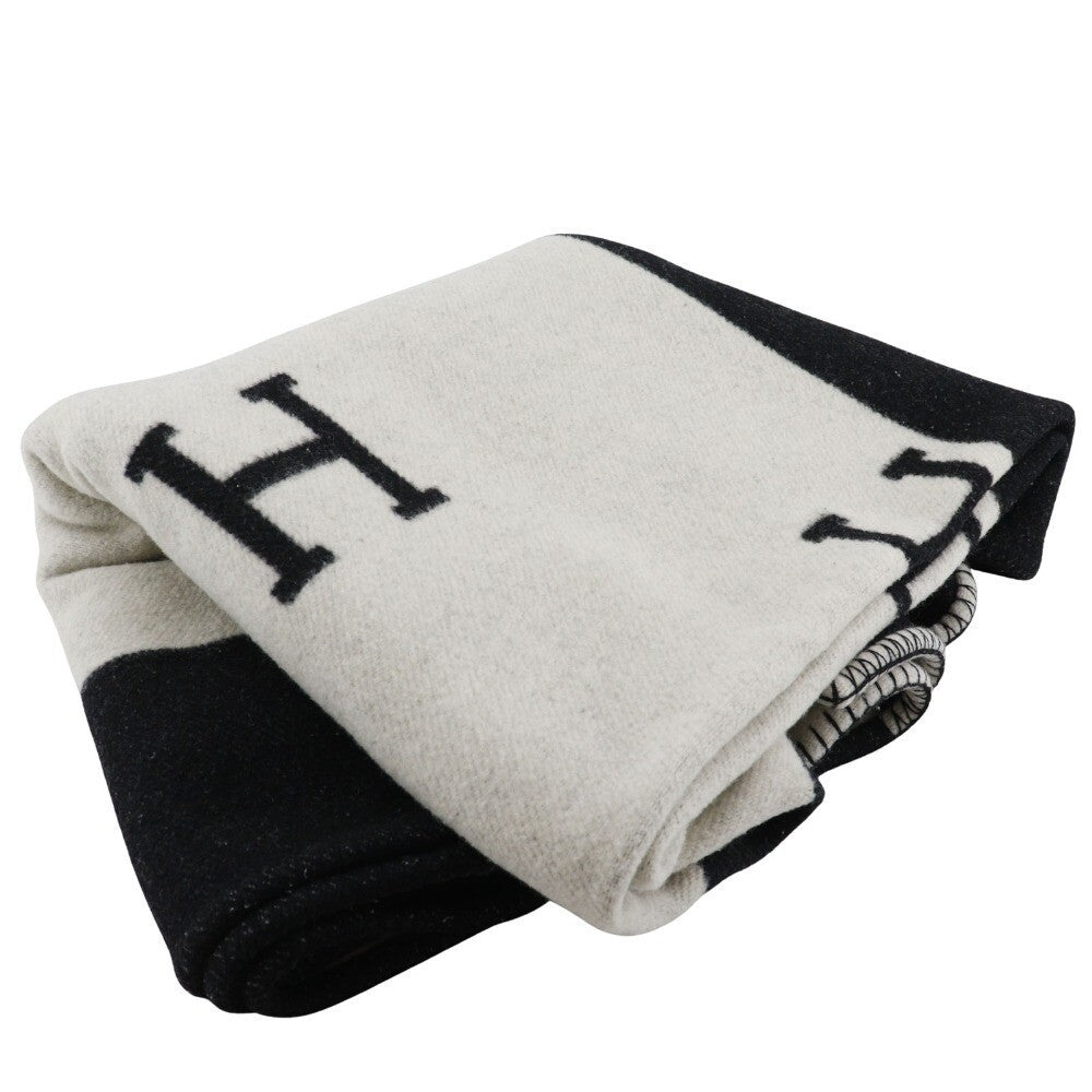 Folded blanket with letter 'H' on a white background