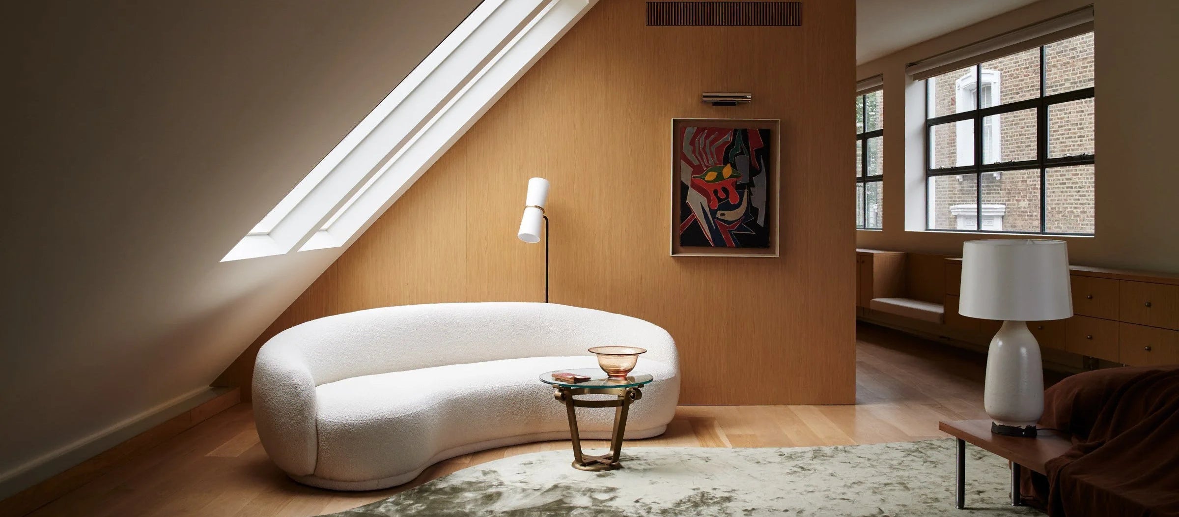Modern living room with a white sofa, coffee table, and wall art.