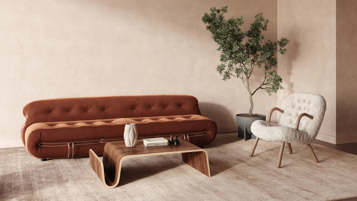 Modern living room with a brown sofa, white armchair, and a small walnut table.