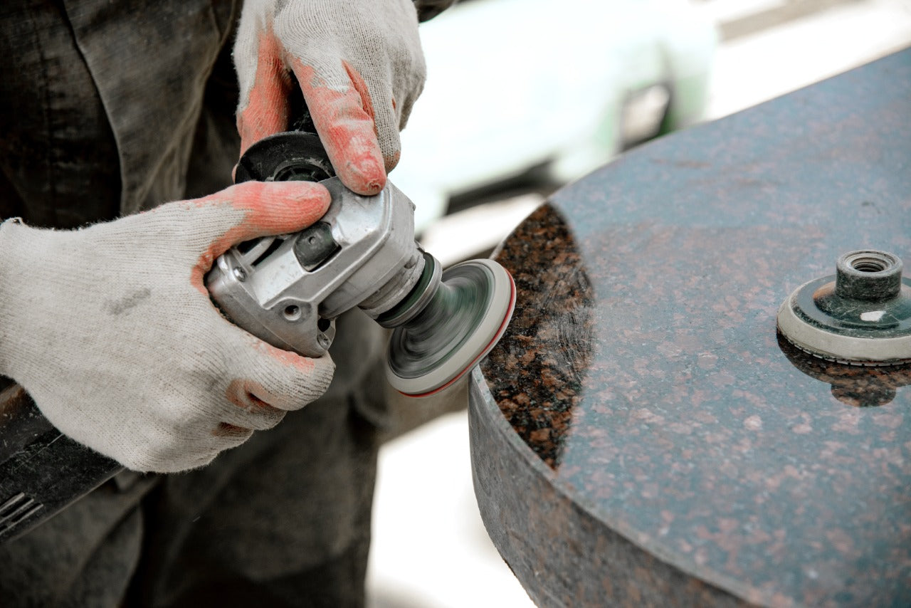 Person using a grinder on a marble stone surface