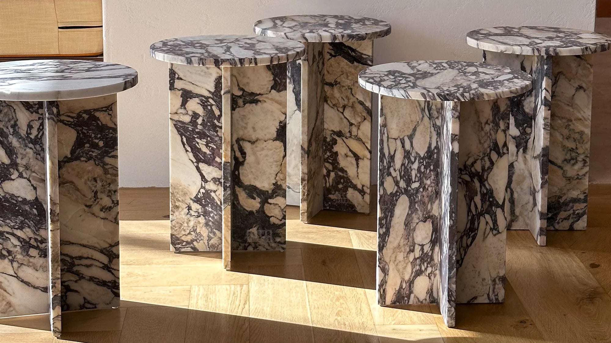 Set of marble-patterned side tables on a wooden floor.