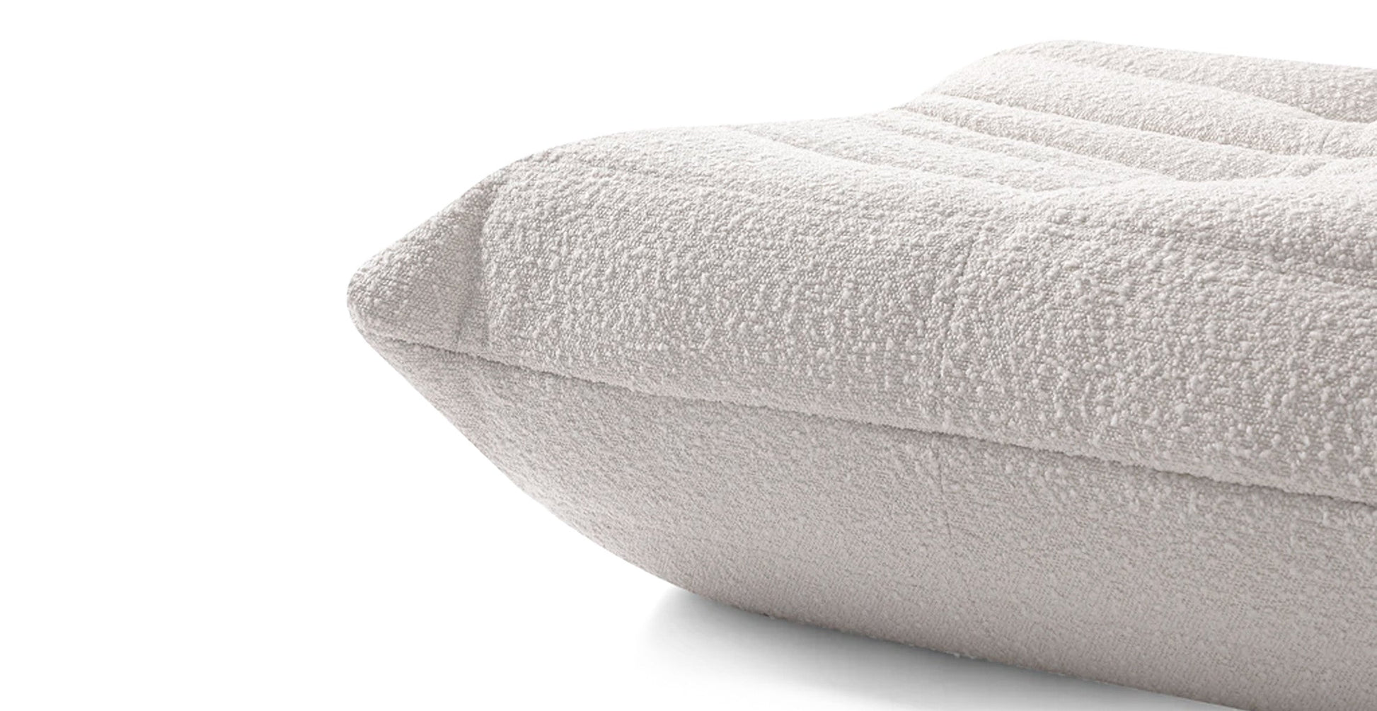 boucle off white low profile sofa in a white background close up shot fabric