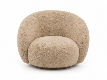 A modern, rounded lounge chair upholstered in genuine shearling fabric in a light beige color, shown against a plain white background.
