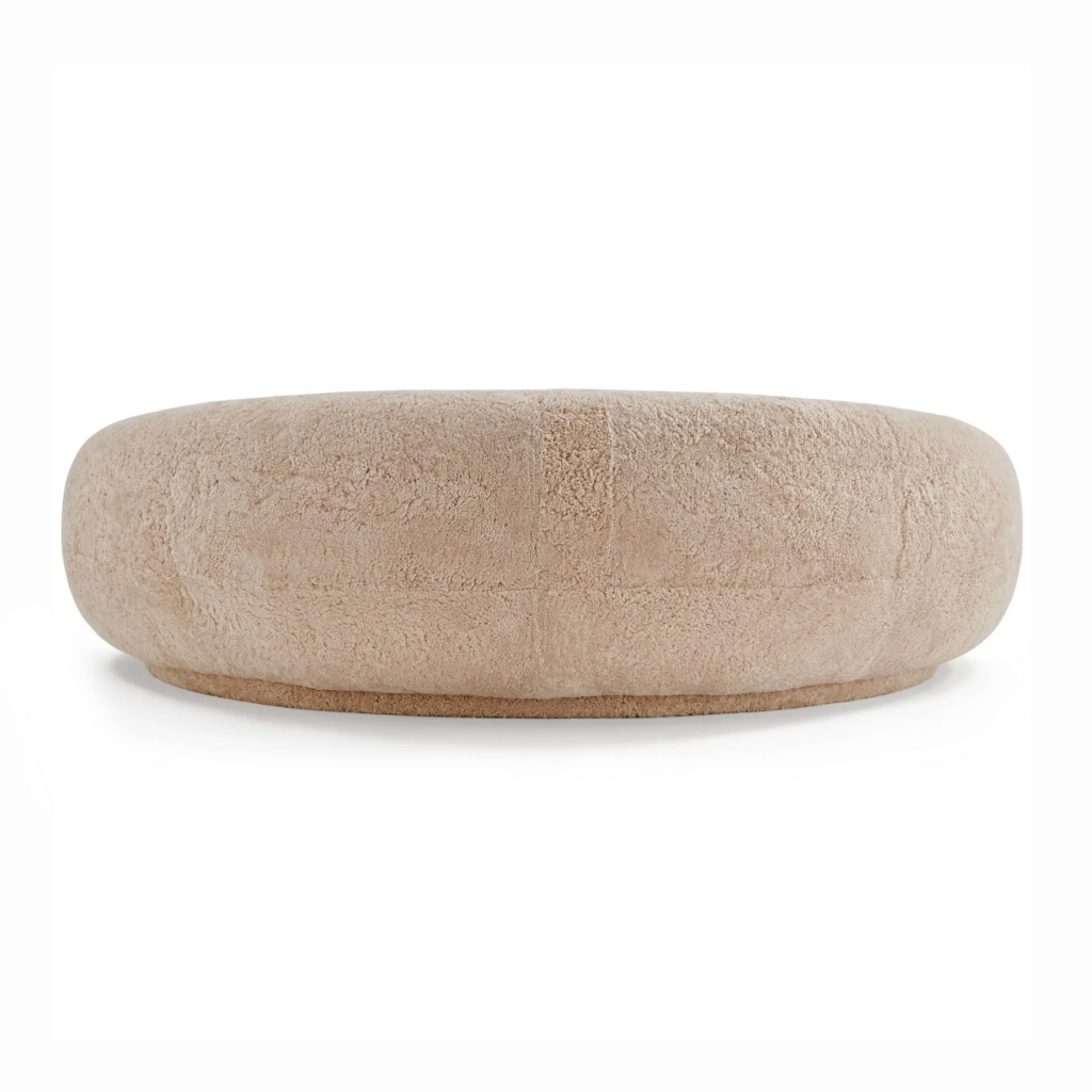 Beige moon shaped sofa ingenuine sheepskin on a white background