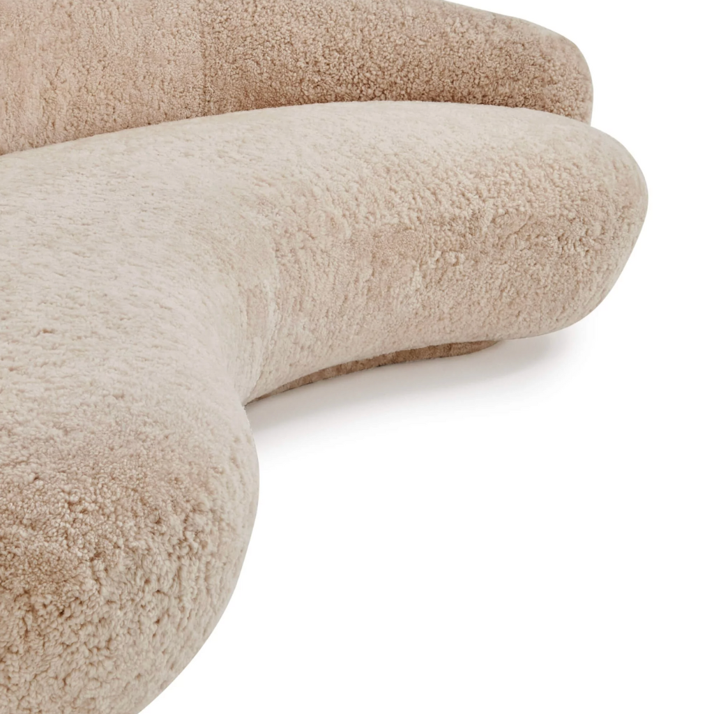 Close-up of a beige, textured sheepskin sofa on a white background